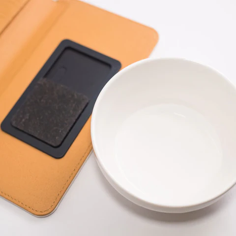 粘着シート洗浄に使用する水が入った白い器